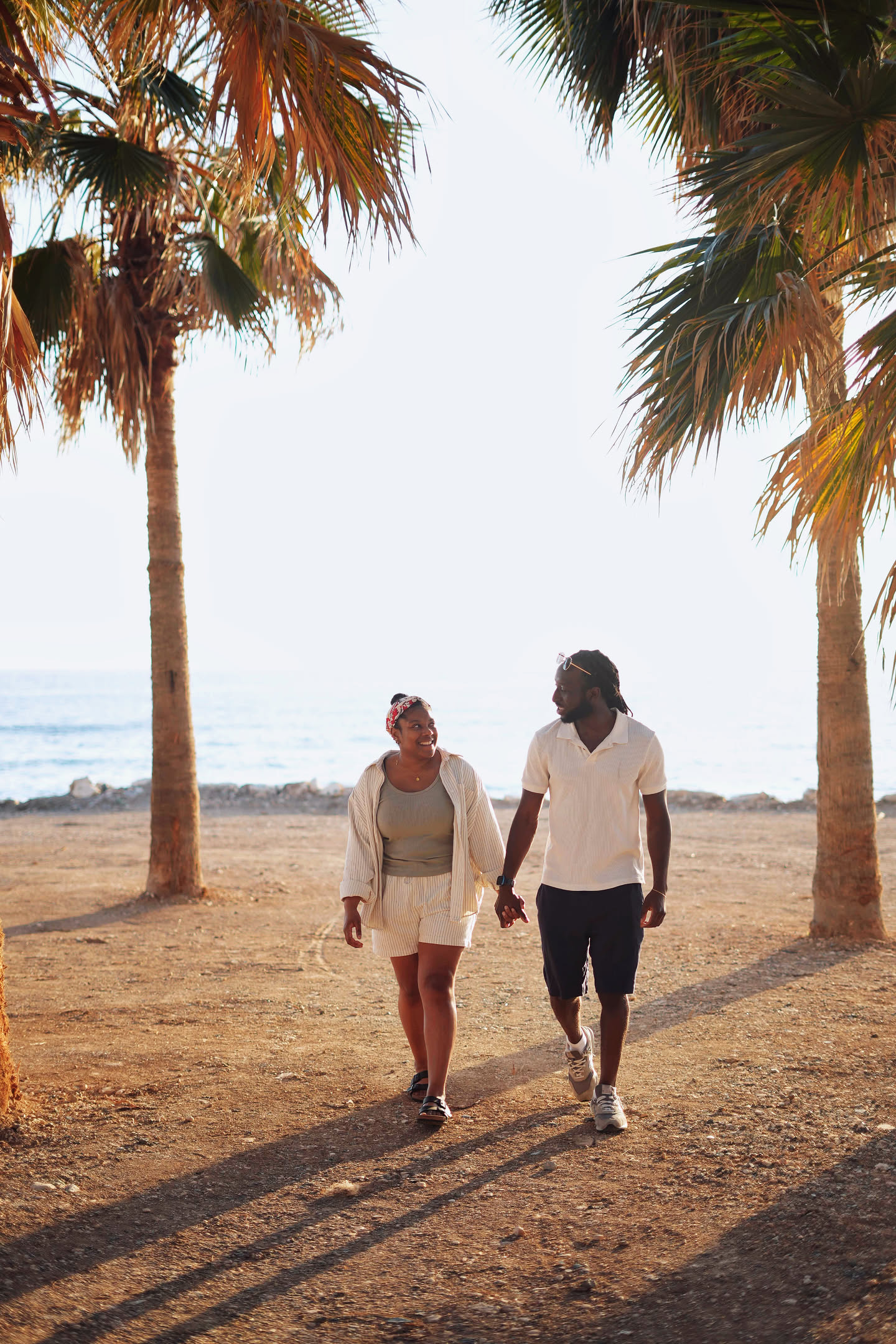 Mike and Lareece walking together beneath palm trees